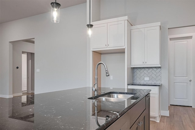 5106 Blooming Hibiscus Ln, Manvel, TX 77578 - kitchen with a sink, decorative backsplash, white cabinetry, dark stone counters, and pendant lighting
