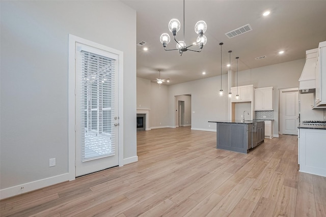 5106 Blooming Hibiscus Ln, Manvel, TX 77578 - kitchen featuring dark countertops, open floor plan, light wood-type flooring, white cabinets, and recessed lighting