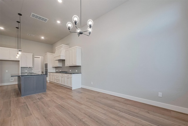 5106 Blooming Hibiscus Ln, Manvel, TX 77578 - kitchen with dark countertops, decorative backsplash, custom range hood, white cabinets, and baseboards