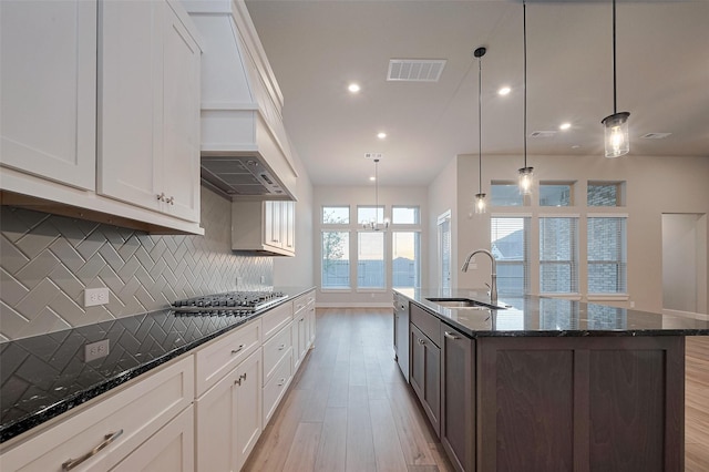 5106 Blooming Hibiscus Ln, Manvel, TX 77578 - kitchen with a sink, custom range hood, light wood-style floors, tasteful backsplash, and recessed lighting
