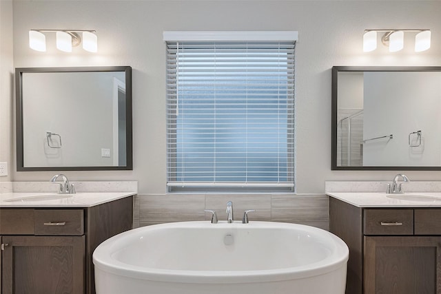 5106 Blooming Hibiscus Ln, Manvel, TX 77578 - bathroom featuring a freestanding bath and two vanities