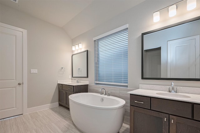 5106 Blooming Hibiscus Ln, Manvel, TX 77578 - full bathroom featuring a freestanding bath, two vanities, and baseboards