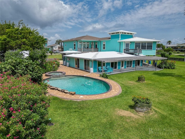 815 5th St, San Leon, TX 77539 - rear view of house featuring a balcony, a pool with connected hot tub, a patio area, and a yard