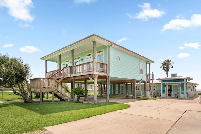 815 5th St, San Leon, TX 77539 - back of house featuring a porch, a carport, concrete driveway, and stairs