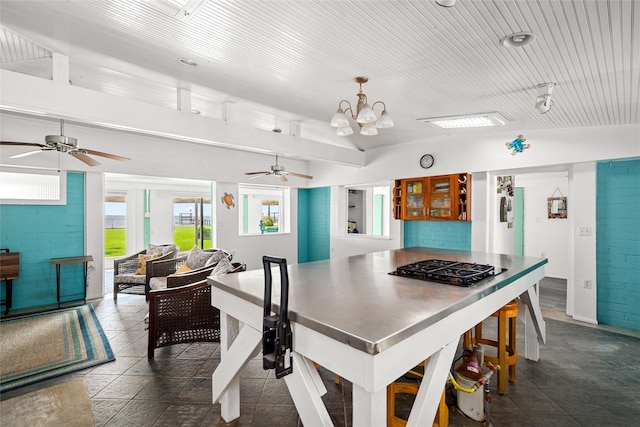 815 5th St, San Leon, TX 77539 - kitchen with a ceiling fan, a chandelier, gas stovetop, pendant lighting, and brick wall