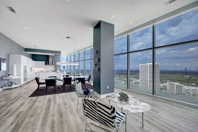 4521 San Felipe St Unit 2701, Houston, TX 77027 - living room featuring wood finished floors, expansive windows, a city view, and baseboards