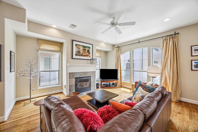 574 Bomar St, Houston, TX 77006 - living area with baseboards, light wood-style flooring, ceiling fan, a tiled fireplace, and recessed lighting