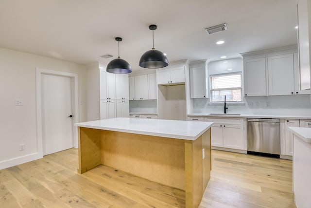 2519 Parana Dr, Houston, TX 77080 - kitchen featuring stainless steel dishwasher, a sink, light wood-type flooring, a center island, and white cabinets