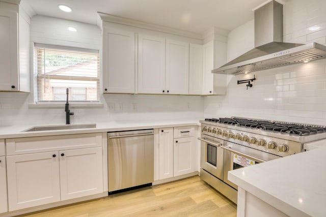 2519 Parana Dr, Houston, TX 77080 - kitchen featuring wall chimney range hood, appliances with stainless steel finishes, a sink, tasteful backsplash, and light countertops