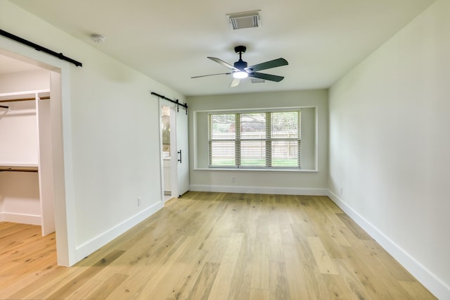 2519 Parana Dr, Houston, TX 77080 - unfurnished bedroom with a barn door, light wood-style flooring, a spacious closet, and baseboards