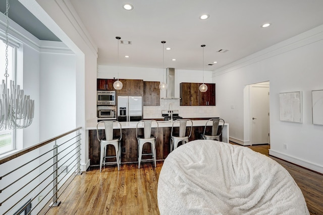 5317 Lillian St, Houston, TX 77007 - kitchen with appliances with stainless steel finishes, wall chimney exhaust hood, a kitchen bar, light countertops, and tasteful backsplash