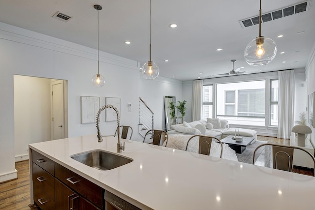 5317 Lillian St, Houston, TX 77007 - kitchen with a sink, dark wood finished floors, light countertops, dark brown cabinetry, and recessed lighting
