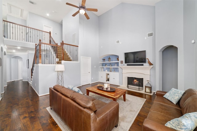 25303 Hall Meadow Ln, Katy, TX 77494 - living area featuring arched walkways, a towering ceiling, a ceiling fan, stairway, and hardwood / wood-style floors