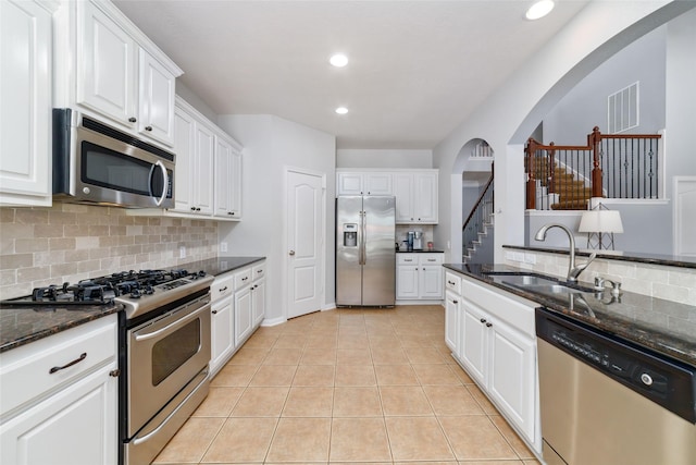 25303 Hall Meadow Ln, Katy, TX 77494 - kitchen with stainless steel appliances, arched walkways, a sink, decorative backsplash, and recessed lighting