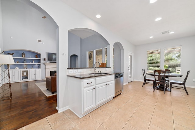 25303 Hall Meadow Ln, Katy, TX 77494 - kitchen with stainless steel dishwasher, a sink, light tile patterned floors, white cabinets, and recessed lighting