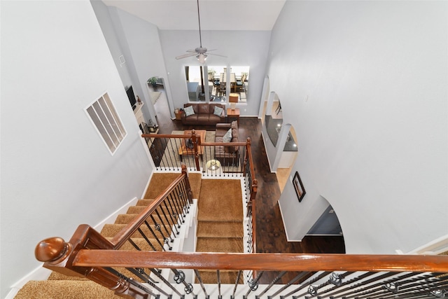 25303 Hall Meadow Ln, Katy, TX 77494 - stairway featuring baseboards, ceiling fan, wood finished floors, and a towering ceiling