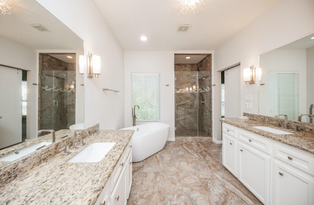 4311 Childress St, Houston, TX 77005 - bathroom featuring two vanities, marble finish flooring, a stall shower, a freestanding tub, and recessed lighting