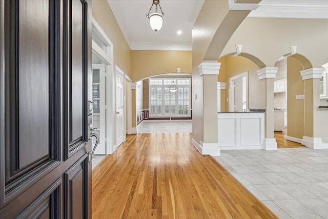 1214 Turnbury Oak Ln, Houston, TX 77055 - entryway featuring ornate columns, arched walkways, crown molding, light wood-style flooring, and baseboards