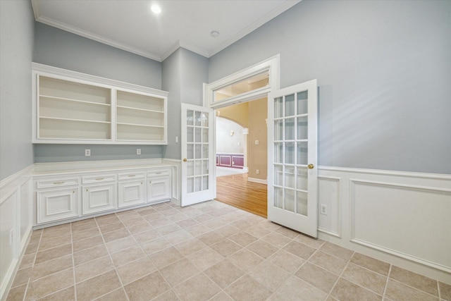 1214 Turnbury Oak Ln, Houston, TX 77055 - unfurnished room featuring french doors, ornamental molding, light tile patterned flooring, a wainscoted wall, and a decorative wall