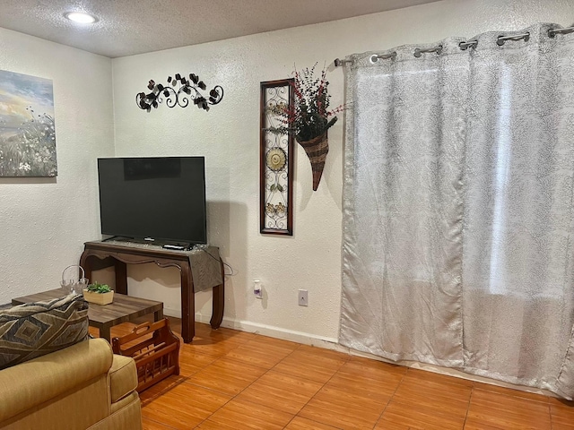 12660 Ashford Point Dr Unit 811, Houston, TX 77082 - living area with a textured wall, a textured ceiling, and baseboards