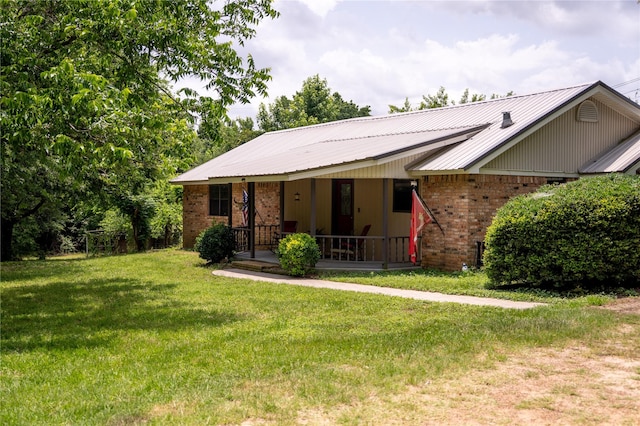 1933 Fm 1272, Grapeland, TX 75844 - view of front facade with brick siding, a front lawn, a porch, and metal roof