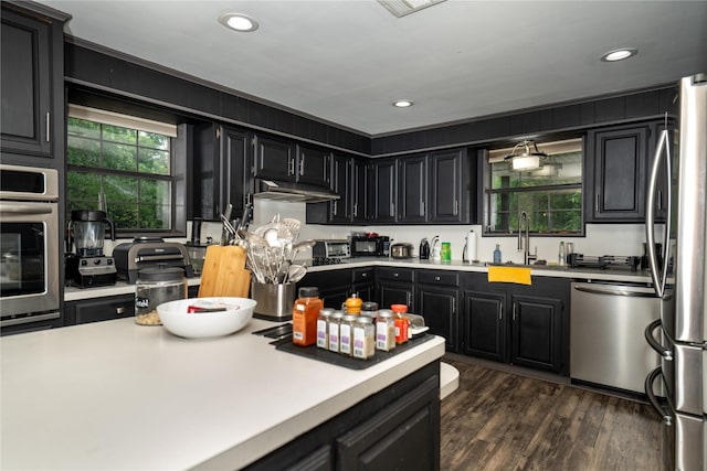 1933 Fm 1272, Grapeland, TX 75844 - kitchen featuring appliances with stainless steel finishes, dark cabinets, light countertops, dark wood-type flooring, and recessed lighting