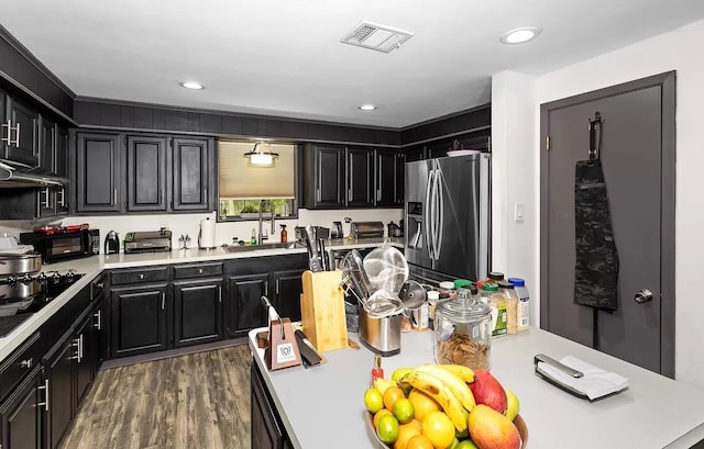 1933 Fm 1272, Grapeland, TX 75844 - kitchen featuring stainless steel refrigerator with ice dispenser, a sink, light countertops, dark cabinets, and wood finished floors