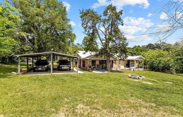 1933 Fm 1272, Grapeland, TX 75844 - rear view of house featuring a detached carport, a yard, and a fire pit