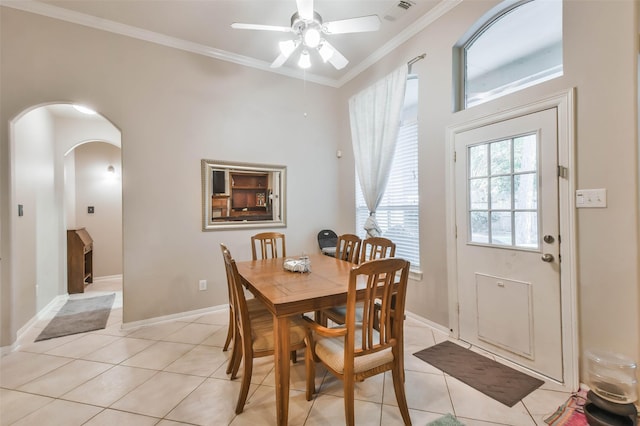 12202 Salt River Valley Ln, Humble, TX 77346 - dining space with ceiling fan, arched walkways, crown molding, light tile patterned floors, and baseboards