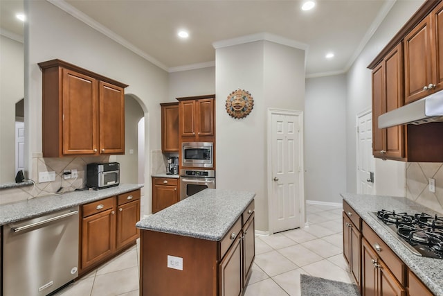 12202 Salt River Valley Ln, Humble, TX 77346 - kitchen featuring appliances with stainless steel finishes, backsplash, arched walkways, light tile patterned flooring, and crown molding