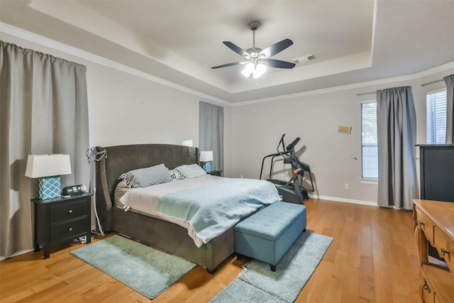 12202 Salt River Valley Ln, Humble, TX 77346 - bedroom with a tray ceiling, light wood-style flooring, a ceiling fan, baseboards, and ornamental molding