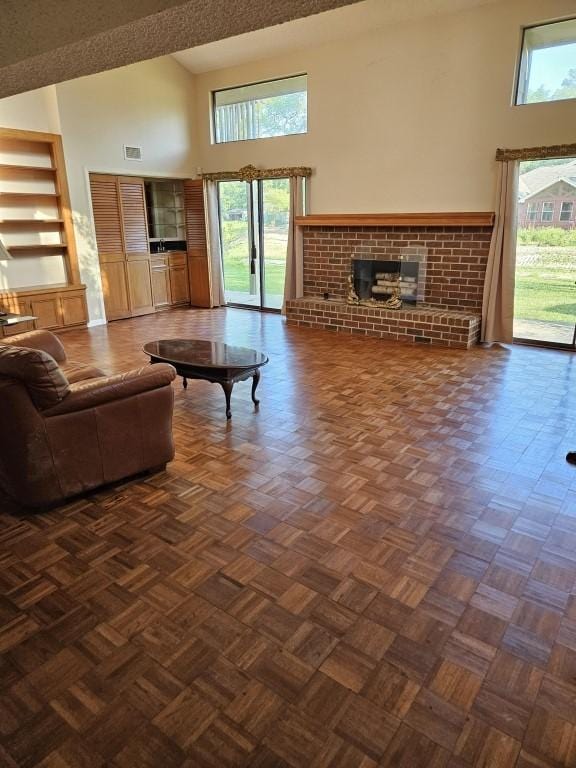 19634 Enchanted Oaks Dr, Spring, TX 77388 - living area featuring a high ceiling, a brick fireplace, built in features, and healthy amount of natural light