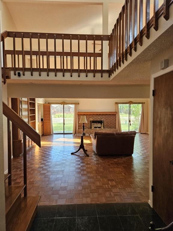 19634 Enchanted Oaks Dr, Spring, TX 77388 - living room with a towering ceiling, healthy amount of natural light, and a brick fireplace