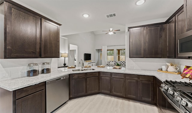 18817 Lucas Michael Way, New Caney, TX 77357 - kitchen featuring appliances with stainless steel finishes, a sink, dark brown cabinetry, backsplash, and a ceiling fan