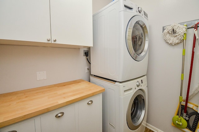 4134 Foxbrush Ln, Sugar Land, TX 77479 - laundry area with cabinet space, estacked washer and dryer, and baseboards