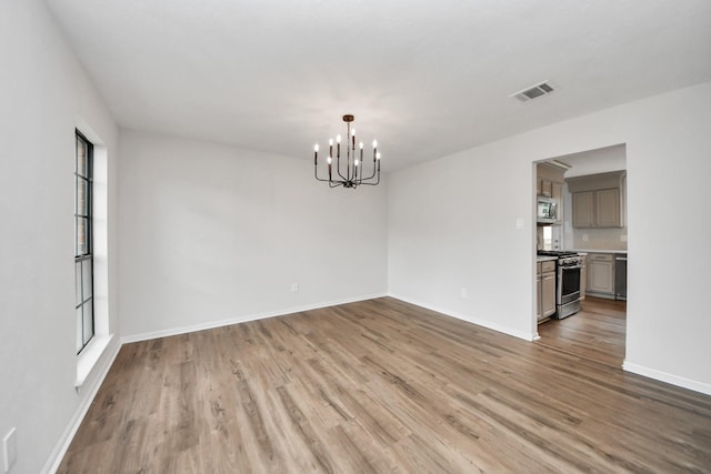 7622 Shangrila Ln, Houston, TX 77095 - empty room with a chandelier, light wood finished floors, healthy amount of natural light, and baseboards