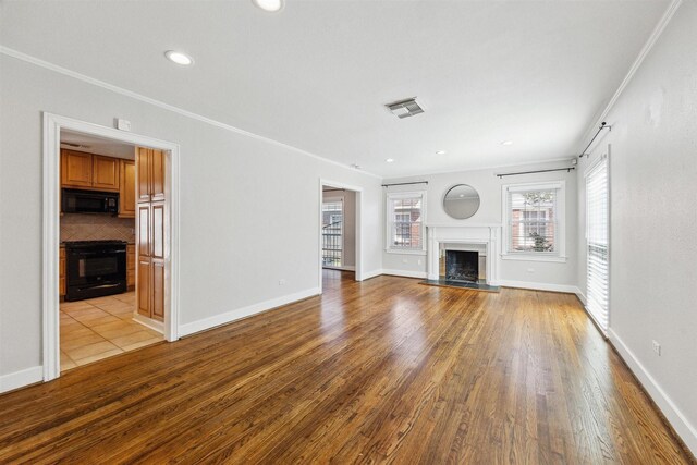 6649 Fairfield St, Houston, TX 77023 - unfurnished living room with a fireplace, wood finished floors, crown molding, baseboards, and recessed lighting