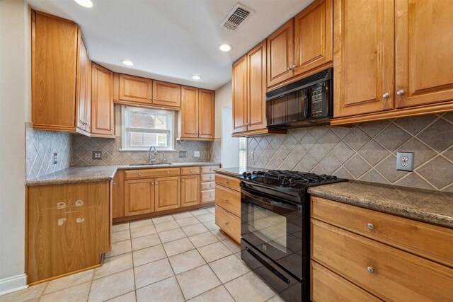 6649 Fairfield St, Houston, TX 77023 - kitchen with black appliances, a sink, light tile patterned flooring, decorative backsplash, and brown cabinets