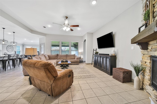 28111 Middlewater View Ln, Katy, TX 77494 - living room featuring light tile patterned floors, a fireplace, recessed lighting, a ceiling fan, and arched walkways