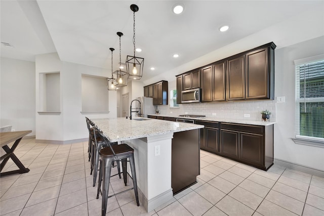 28111 Middlewater View Ln, Katy, TX 77494 - kitchen featuring stainless steel appliances, a sink, light tile patterned floors, backsplash, and recessed lighting