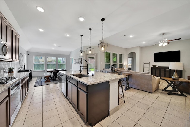 28111 Middlewater View Ln, Katy, TX 77494 - kitchen with a sink, stainless steel appliances, light tile patterned floors, a breakfast bar, and recessed lighting