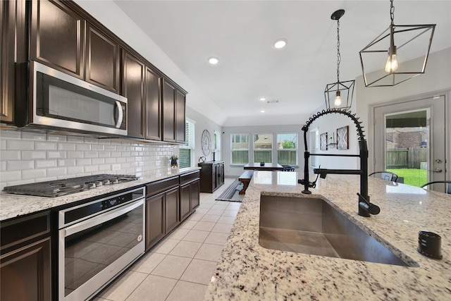 28111 Middlewater View Ln, Katy, TX 77494 - kitchen with appliances with stainless steel finishes, a sink, light tile patterned floors, hanging light fixtures, and recessed lighting