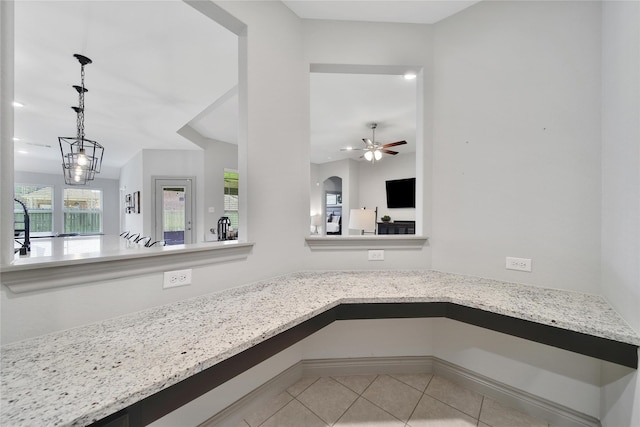 28111 Middlewater View Ln, Katy, TX 77494 - kitchen featuring light tile patterned floors, decorative light fixtures, a ceiling fan, and light stone counters
