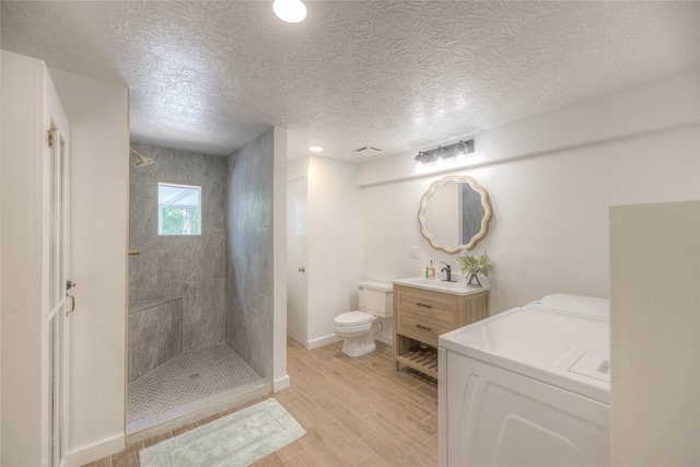 517 Lakeview Hbr, Onalaska, TX 77360 - full bath featuring washer and dryer, a walk in shower, vanity, wood tiled floors, and toilet