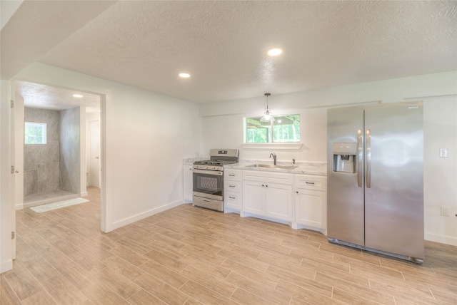 517 Lakeview Hbr, Onalaska, TX 77360 - kitchen with stainless steel appliances, a sink, a textured ceiling, white cabinets, and baseboards