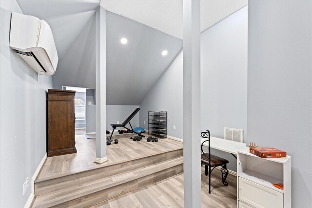 18226 Ennsbury Dr, Houston, TX 77084 - exercise room featuring lofted ceiling, light wood-style flooring, an AC wall unit, baseboards, and recessed lighting