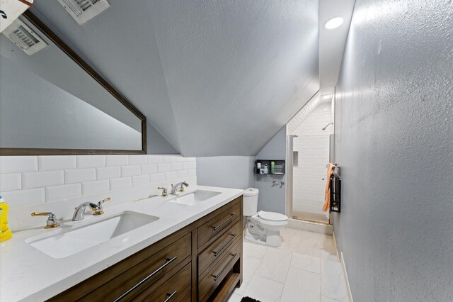 18226 Ennsbury Dr, Houston, TX 77084 - bathroom featuring toilet, double vanity, a shower stall, lofted ceiling, and decorative backsplash