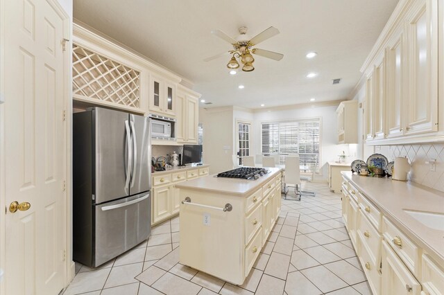 18226 Ennsbury Dr, Houston, TX 77084 - kitchen with appliances with stainless steel finishes, light tile patterned floors, a ceiling fan, a center island, and tasteful backsplash