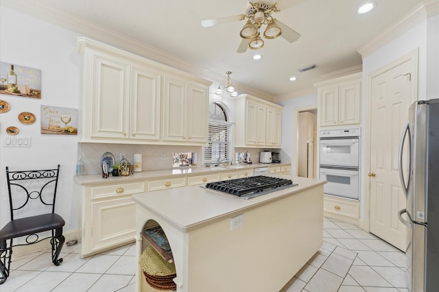 18226 Ennsbury Dr, Houston, TX 77084 - kitchen featuring stainless steel appliances, ceiling fan, a kitchen island, crown molding, and light tile patterned flooring