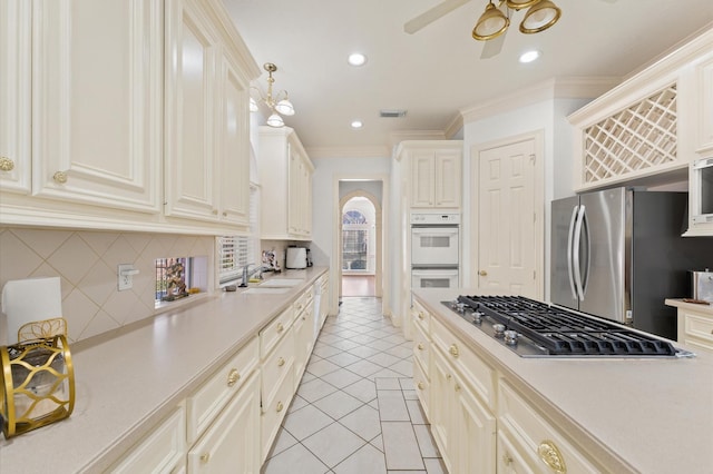 18226 Ennsbury Dr, Houston, TX 77084 - kitchen with stainless steel appliances, light countertops, backsplash, crown molding, and recessed lighting